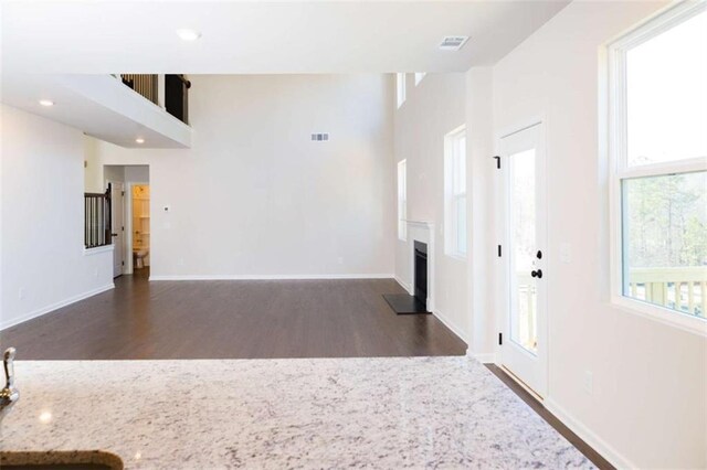 unfurnished living room featuring a fireplace, recessed lighting, visible vents, wood finished floors, and baseboards