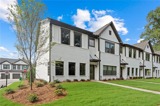 view of front of home with brick siding, a front lawn, and board and batten siding