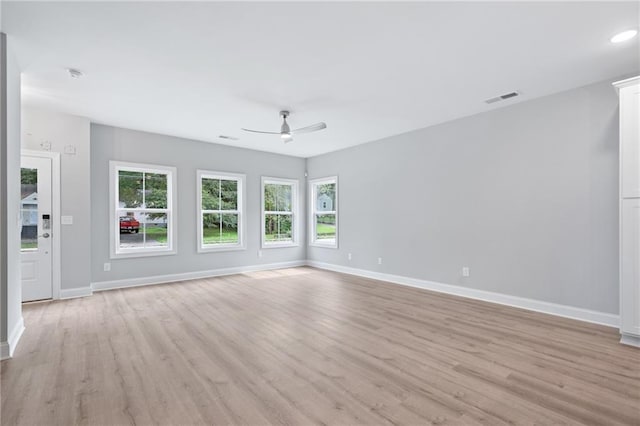 unfurnished living room featuring visible vents, light wood-style flooring, and baseboards