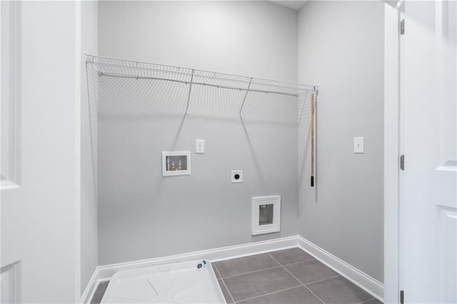 laundry room featuring hookup for a washing machine, electric dryer hookup, laundry area, dark tile patterned floors, and baseboards