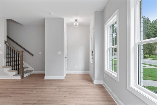 entryway featuring a healthy amount of sunlight, light wood-style flooring, and stairs