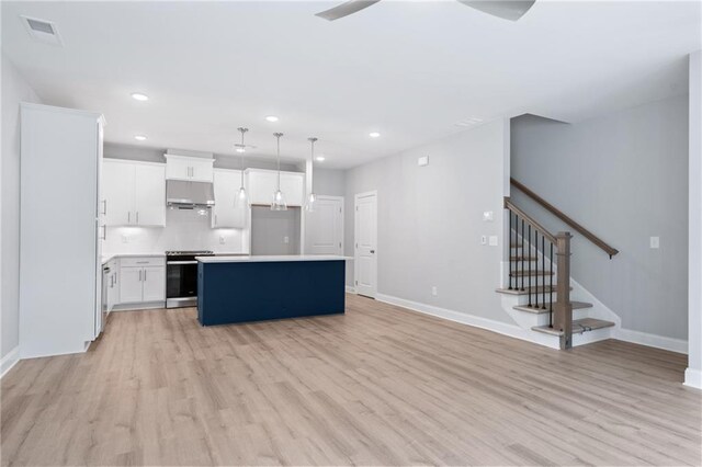 kitchen with white cabinetry, stainless steel range oven, light countertops, a center island, and decorative light fixtures