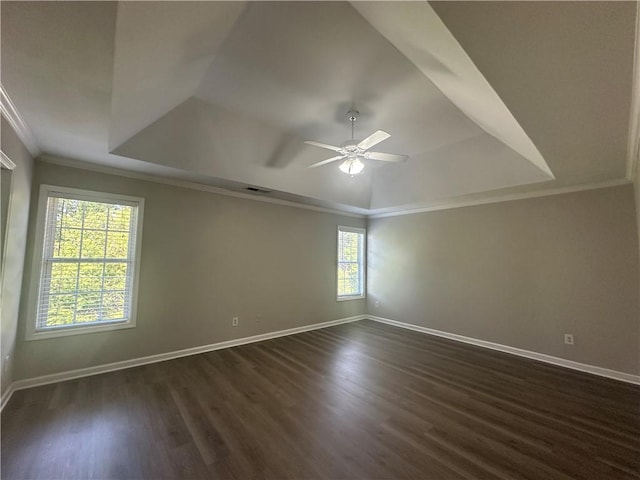 unfurnished room featuring baseboards, a ceiling fan, dark wood finished floors, and a tray ceiling