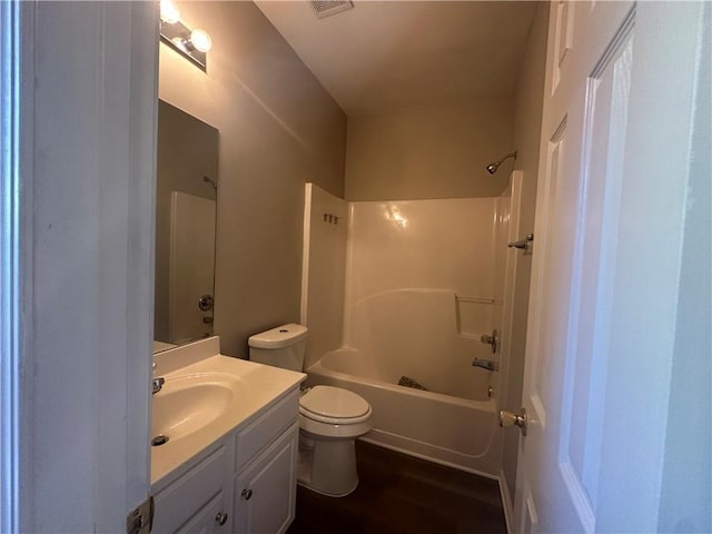 full bath with visible vents, vanity, wood finished floors, toilet, and shower / tub combination