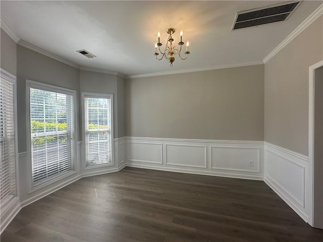 empty room featuring crown molding, dark wood-type flooring, a chandelier, and visible vents