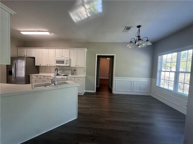 kitchen with dark wood finished floors, light countertops, white cabinets, an inviting chandelier, and white appliances