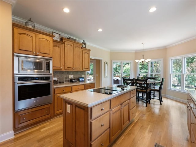 4523 Warwick Glen Pl, Flowery Branch, GA 30542 - kitchen featuring stainless steel appliances, a chandelier, a kitchen island, light wood-style flooring, and light countertops