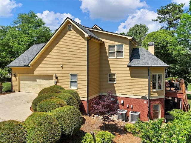 4523 Warwick Glen Pl, Flowery Branch, GA 30542 - view of property exterior featuring a chimney, central AC, concrete driveway, an attached garage, and roof with shingles