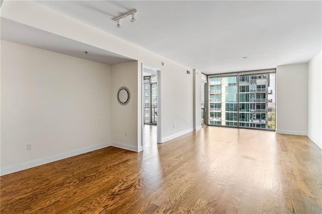 interior space featuring expansive windows, track lighting, and hardwood / wood-style flooring