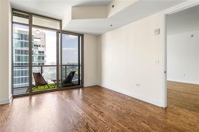 unfurnished room with hardwood / wood-style flooring and floor to ceiling windows