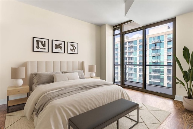 bedroom with access to exterior and light wood-type flooring