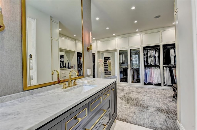 bathroom featuring recessed lighting, a spacious closet, and vanity