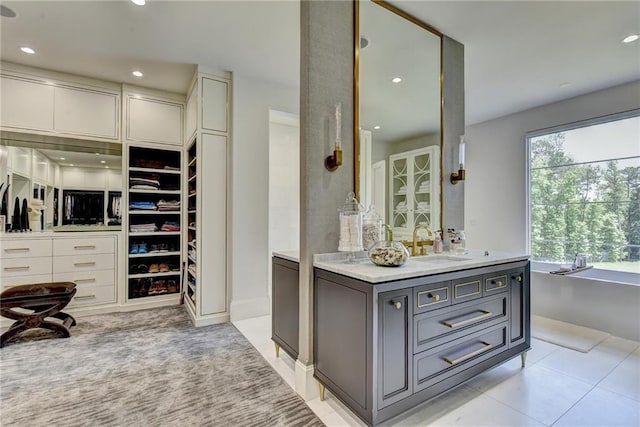 spacious closet with light tile patterned floors and a sink