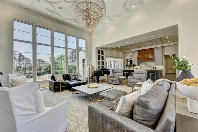 living room with recessed lighting, a high ceiling, a chandelier, and ornamental molding