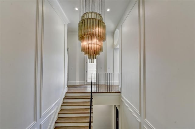 stairs featuring recessed lighting, a decorative wall, and a chandelier