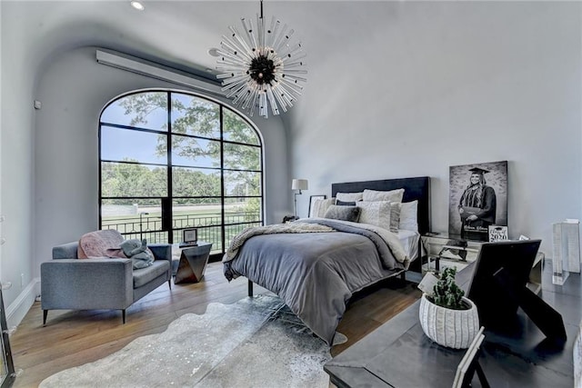 bedroom featuring an inviting chandelier and wood finished floors