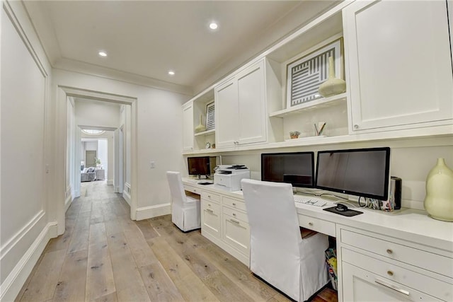 office area with built in desk, light wood-style floors, recessed lighting, baseboards, and ornamental molding