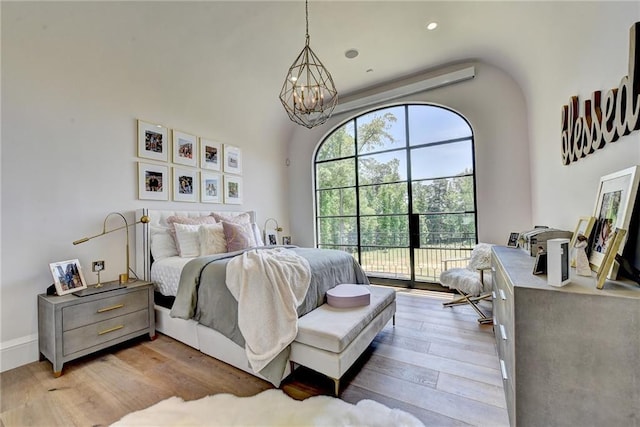 bedroom with wood finished floors and a chandelier
