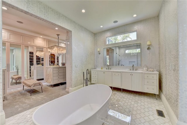 bathroom with visible vents, vanity, recessed lighting, a chandelier, and a soaking tub