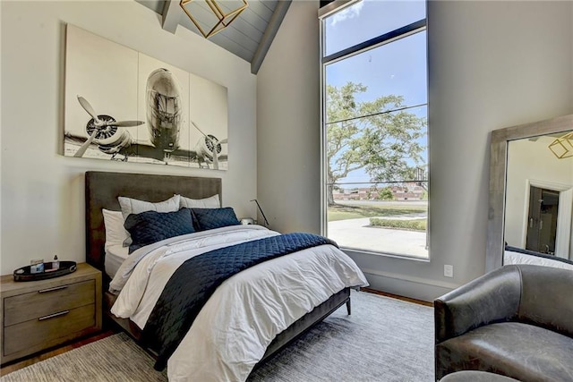 bedroom featuring wood finished floors, vaulted ceiling, and multiple windows