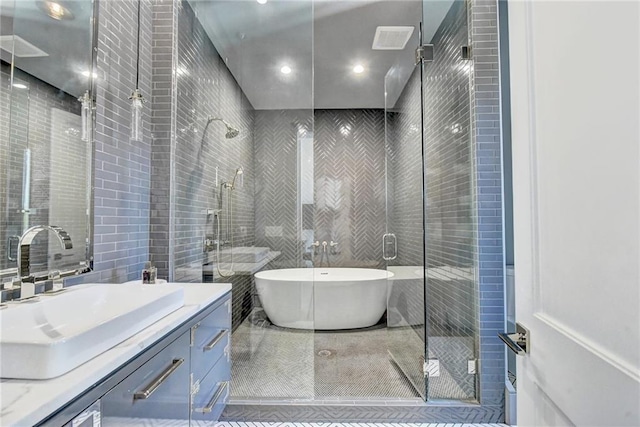 full bath featuring vanity, tile walls, and a stall shower