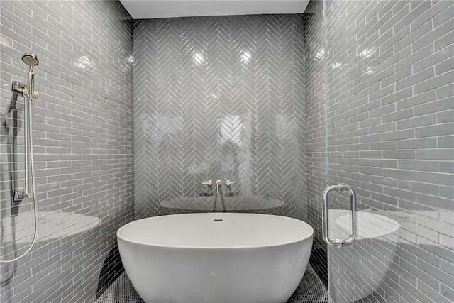full bathroom with tile walls, a shower stall, a soaking tub, and tile patterned flooring