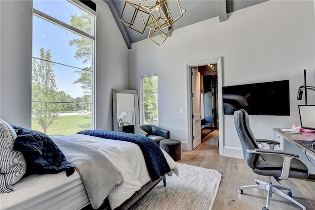 bedroom with an inviting chandelier, light wood-style flooring, baseboards, and vaulted ceiling with beams