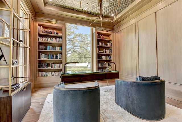 home office with crown molding, built in features, and wood finished floors