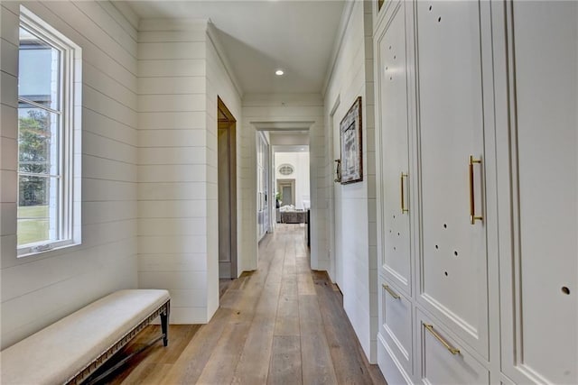hall featuring wood-type flooring, recessed lighting, and wooden walls