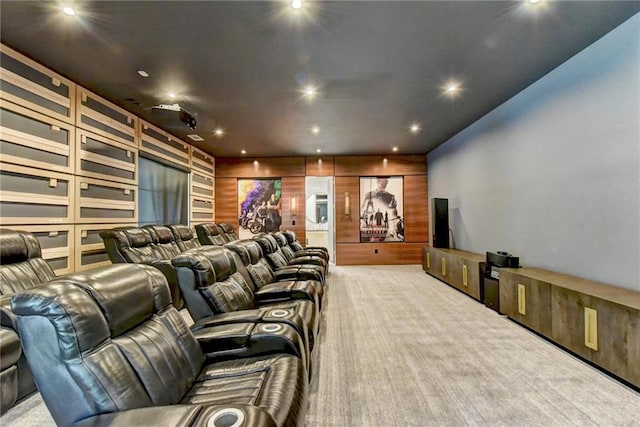 carpeted home theater featuring recessed lighting and wood walls