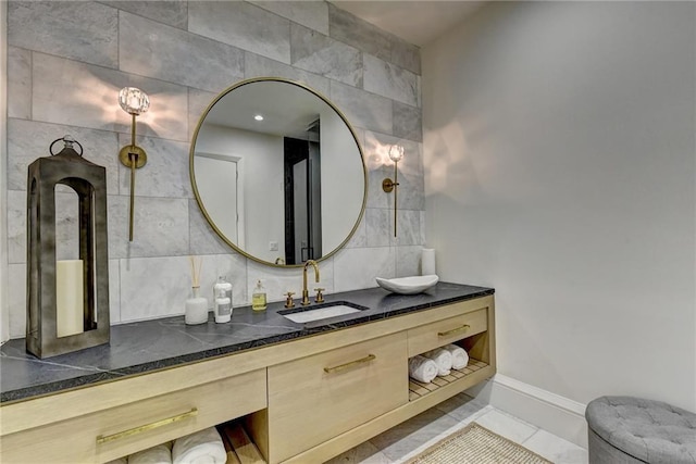bathroom with vanity, decorative backsplash, and baseboards