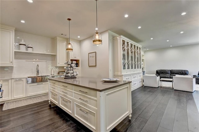 kitchen with white cabinetry, open shelves, a sink, and dark wood-type flooring