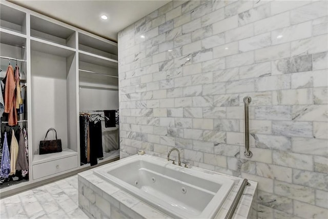 full bathroom with recessed lighting, a spacious closet, a tub with jets, and marble finish floor