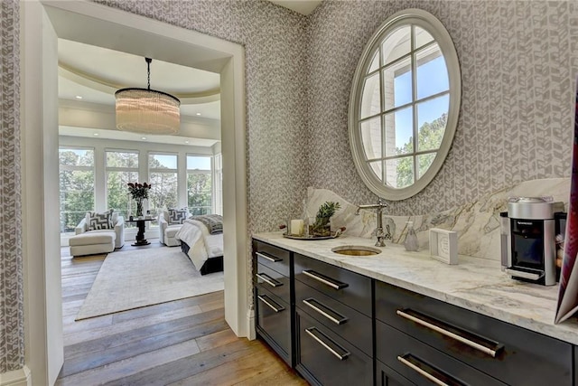ensuite bathroom featuring ensuite bath, tasteful backsplash, hardwood / wood-style flooring, vanity, and wallpapered walls