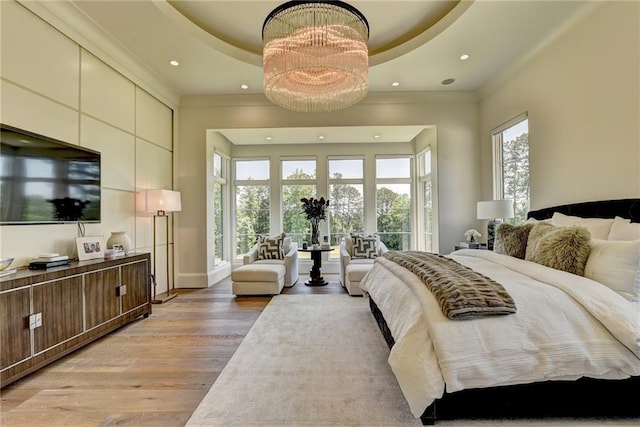 bedroom with recessed lighting, ornamental molding, light wood-style flooring, and a raised ceiling
