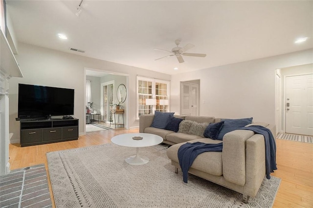 living room featuring wood-type flooring and ceiling fan