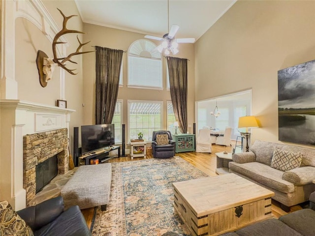 710 Bentgrass Ct, Dacula, GA 30019 - living room with a high ceiling, a stone fireplace, wood finished floors, ceiling fan, and crown molding