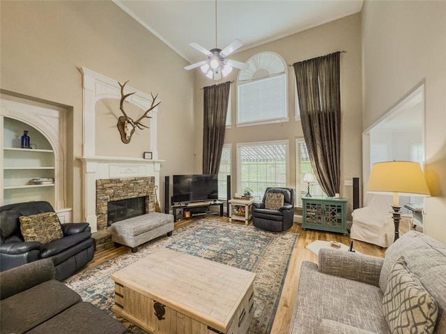710 Bentgrass Ct, Dacula, GA 30019 - living area featuring a high ceiling, wood finished floors, crown molding, a ceiling fan, and a stone fireplace