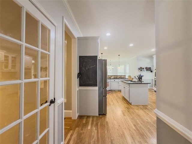 710 Bentgrass Ct, Dacula, GA 30019 - kitchen with freestanding refrigerator, white cabinetry, light wood-type flooring, dark countertops, and pendant lighting