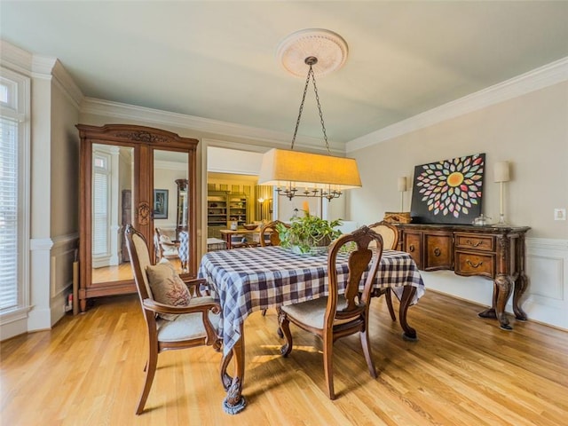 710 Bentgrass Ct, Dacula, GA 30019 - dining space featuring light wood-style flooring, crown molding, a wainscoted wall, and a decorative wall