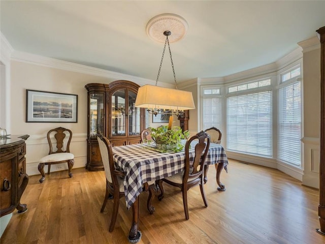 710 Bentgrass Ct, Dacula, GA 30019 - dining room with ornamental molding, light wood-style flooring, wainscoting, and a decorative wall