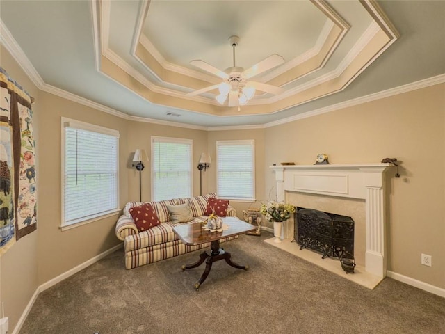 710 Bentgrass Ct, Dacula, GA 30019 - carpeted living area with a tray ceiling, ornamental molding, a fireplace, and a ceiling fan