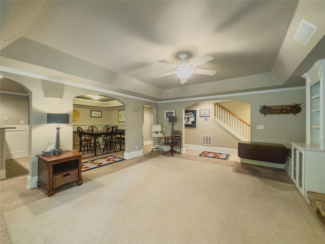 710 Bentgrass Ct, Dacula, GA 30019 - living area with arched walkways, a raised ceiling, ceiling fan, light colored carpet, and stairway