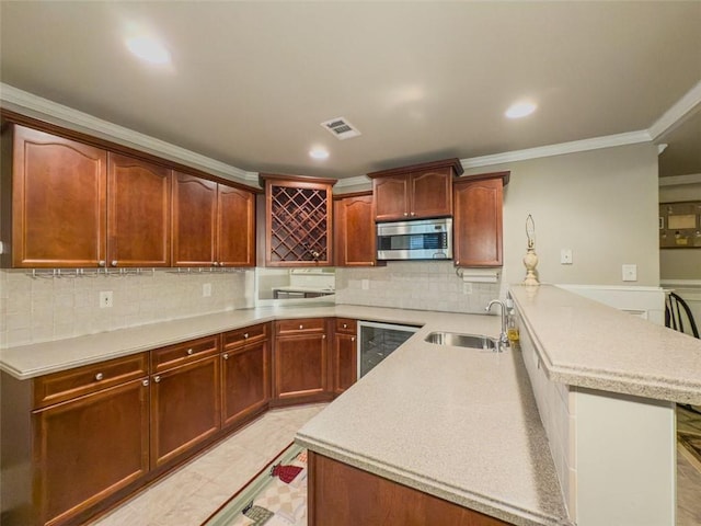 710 Bentgrass Ct, Dacula, GA 30019 - kitchen featuring stainless steel microwave, beverage cooler, a peninsula, light countertops, and ornamental molding