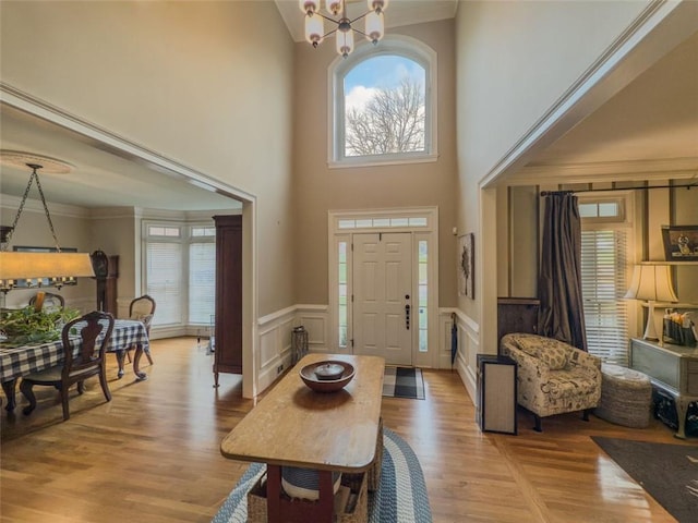 710 Bentgrass Ct, Dacula, GA 30019 - foyer featuring a chandelier, healthy amount of natural light, a wainscoted wall, light wood finished floors, and a towering ceiling