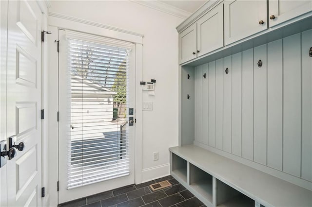 mudroom featuring dark tile patterned floors, visible vents, baseboards, and ornamental molding