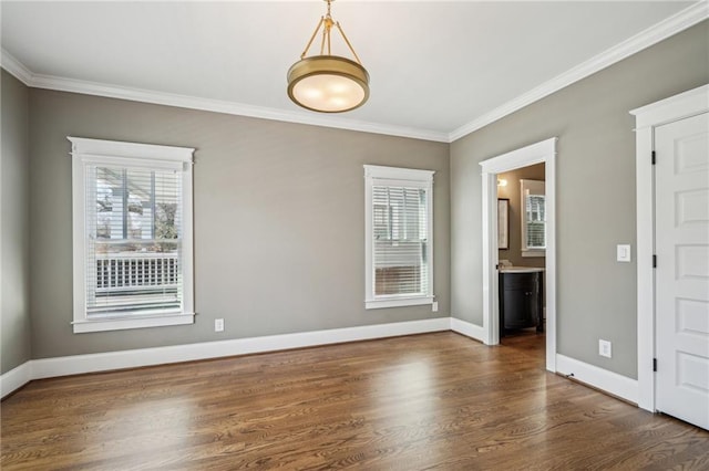 unfurnished room with wood finished floors, baseboards, and ornamental molding