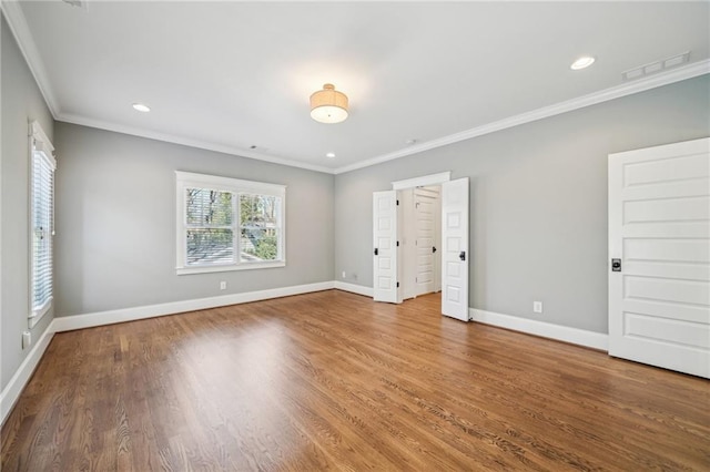 unfurnished bedroom with visible vents, crown molding, baseboards, and wood finished floors