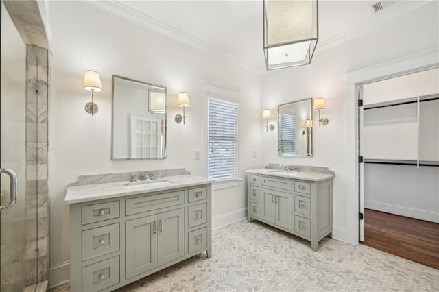 bathroom with two vanities, a sink, a shower stall, crown molding, and baseboards