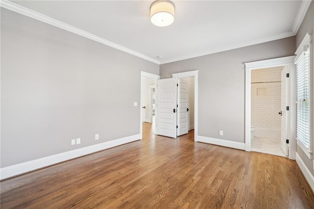 unfurnished bedroom with crown molding, wood finished floors, and baseboards